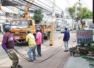 Provincial Electrical Authority workers erect a new utility pole in Naklua, one of a string of 11 leaning and crooked utility poles being replaced between Naklua sois 23 to 29.